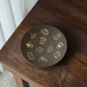 Retro coffee cafe ceramic plate with handpainted barista icons on a dark wooden table