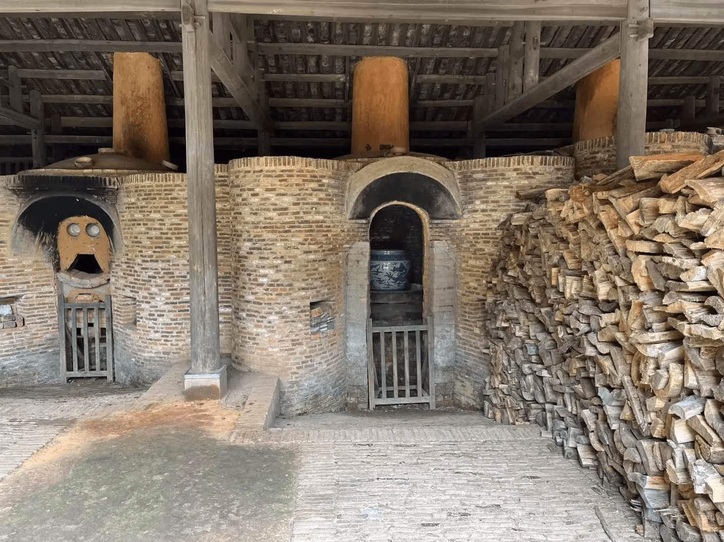 A traditional brick wood-firing kiln filled with pine logs showcasing the history of Jingdezhen ceramics.